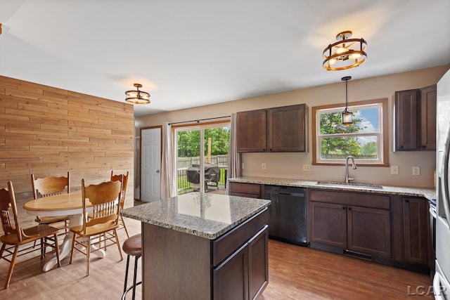 7673 Dalton Rd, Onsted, MI 49265 - kitchen featuring dishwashing machine, light wood-type flooring, wood walls, decorative light fixtures, and a kitchen island