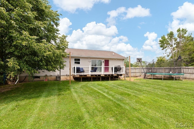 7673 Dalton Rd, Onsted, MI 49265 - back of property featuring a trampoline, a deck, and a fenced backyard