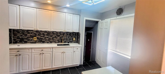 18978 Indiana St, Detroit, MI 48221 - kitchen with dark tile patterned flooring, white cabinets, and backsplash
