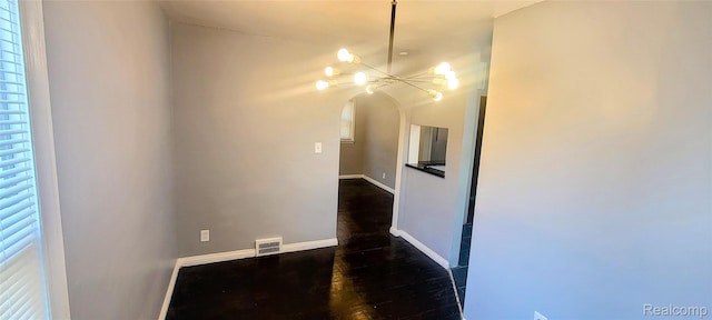 18978 Indiana St, Detroit, MI 48221 - unfurnished room featuring arched walkways, dark wood finished floors, and a chandelier