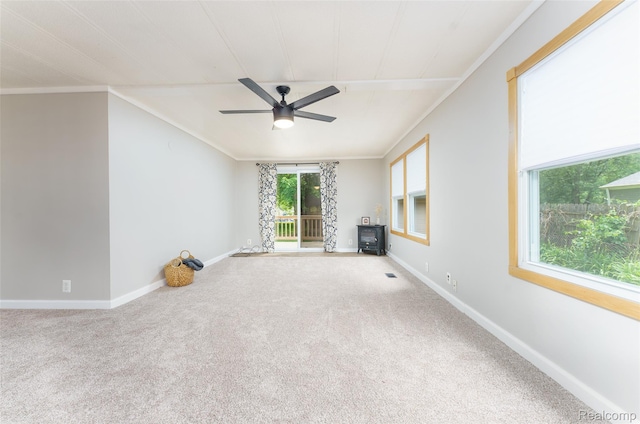 5806 Commanche Ln, Howell, MI 48843 - unfurnished living room with a wood stove, a ceiling fan, carpet floors, and ornamental molding