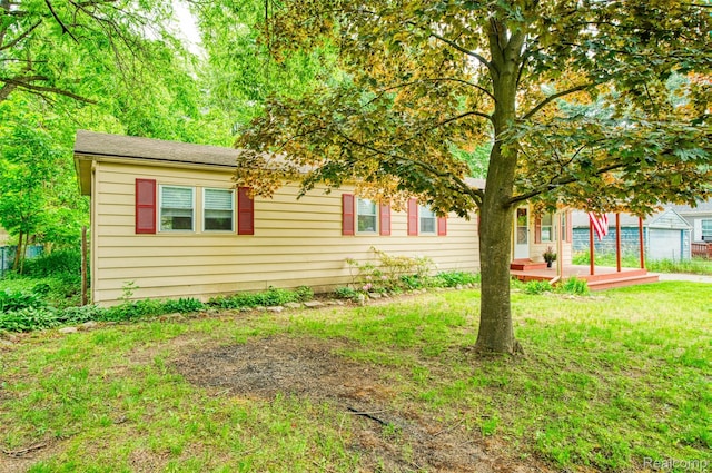 5806 Commanche Ln, Howell, MI 48843 - view of front facade featuring a front yard and a wooden deck