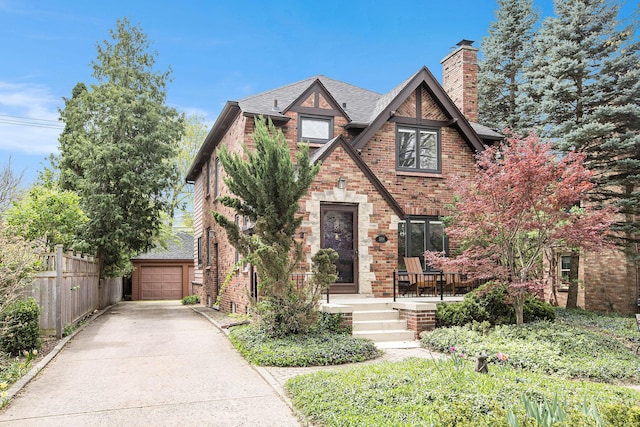 1506 Shadford Rd, Ann Arbor, MI 48104 - tudor house with concrete driveway, brick siding, a chimney, and roof with shingles