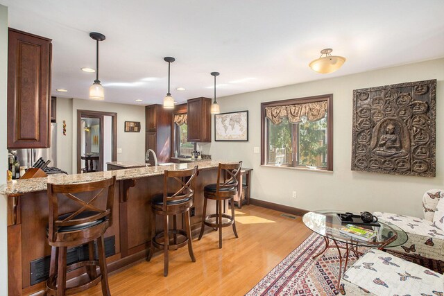1506 Shadford Rd, Ann Arbor, MI 48104 - kitchen with a peninsula, light wood-style flooring, plenty of natural light, light stone counters, and recessed lighting
