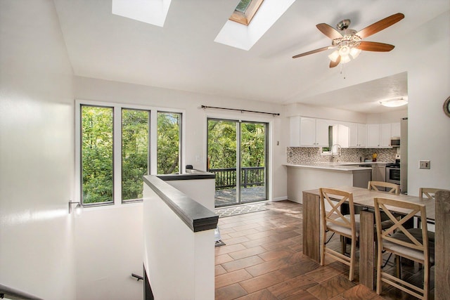 4760 Briarhill Dr, Portage, MI 49024 - kitchen featuring lofted ceiling, stainless steel appliances, backsplash, white cabinetry, and light countertops