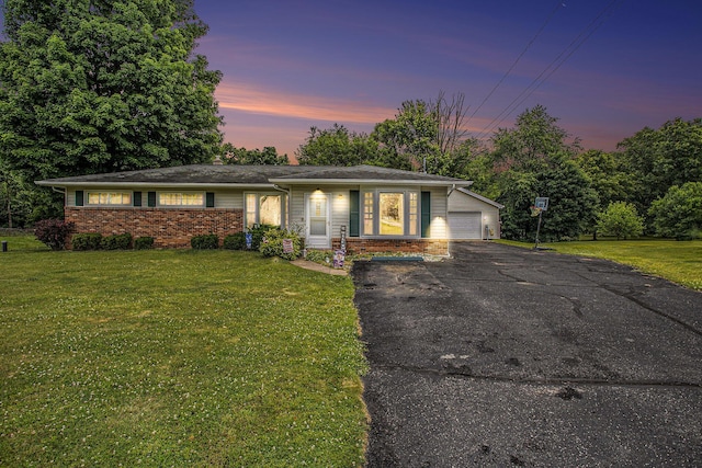 201 Beaumont Dr, Battle Creek, MI 49014 - view of front facade featuring asphalt driveway, a front lawn, brick siding, and a garage