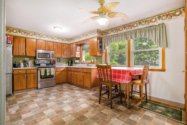 201 Beaumont Dr, Battle Creek, MI 49014 - kitchen with stainless steel appliances, stone finish floors, light countertops, and brown cabinetry