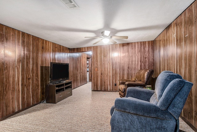 201 Beaumont Dr, Battle Creek, MI 49014 - living area with wood walls, a ceiling fan, and light carpet