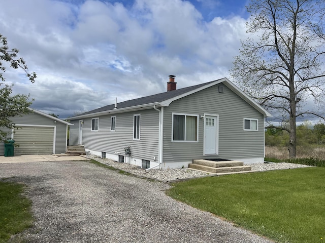 2374 S M 30, West Branch, MI 48661 - back of property with a chimney, an outdoor structure, gravel driveway, a garage, and a yard