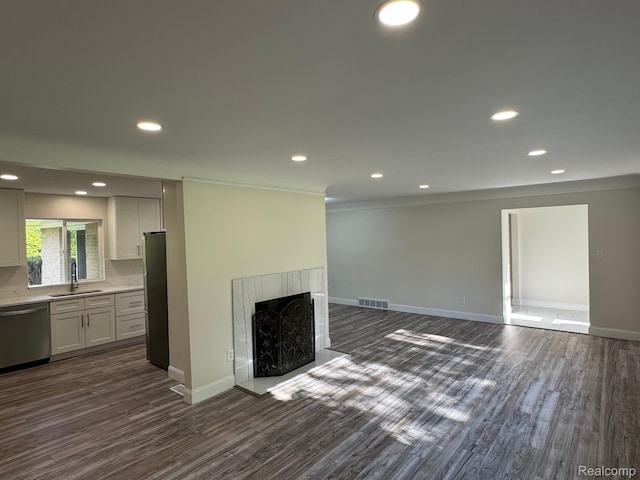 28670 Inkster Rd, Southfield, MI 48034 - unfurnished living room with dark wood-type flooring, a fireplace with raised hearth, recessed lighting, and ornamental molding