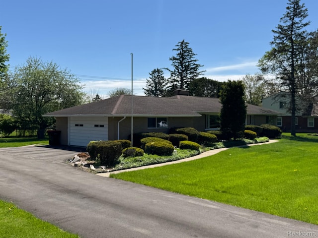 28670 Inkster Rd, Southfield, MI 48034 - ranch-style home with a garage, driveway, a front lawn, a chimney, and stucco siding