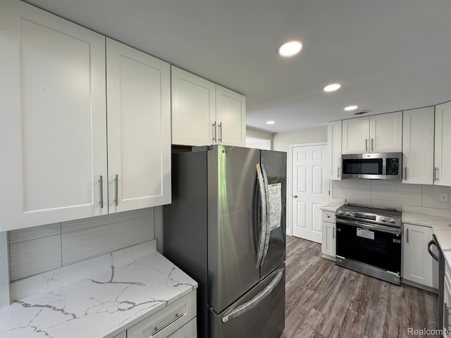 28670 Inkster Rd, Southfield, MI 48034 - kitchen with stainless steel appliances, white cabinetry, tasteful backsplash, light stone counters, and recessed lighting