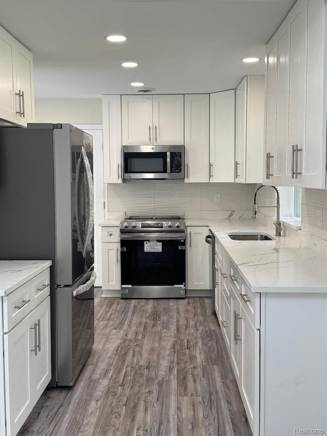 28670 Inkster Rd, Southfield, MI 48034 - kitchen with stainless steel appliances, recessed lighting, white cabinets, dark wood-style floors, and decorative backsplash