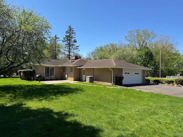 28670 Inkster Rd, Southfield, MI 48034 - view of front facade featuring a front lawn, a chimney, an attached garage, brick siding, and asphalt driveway
