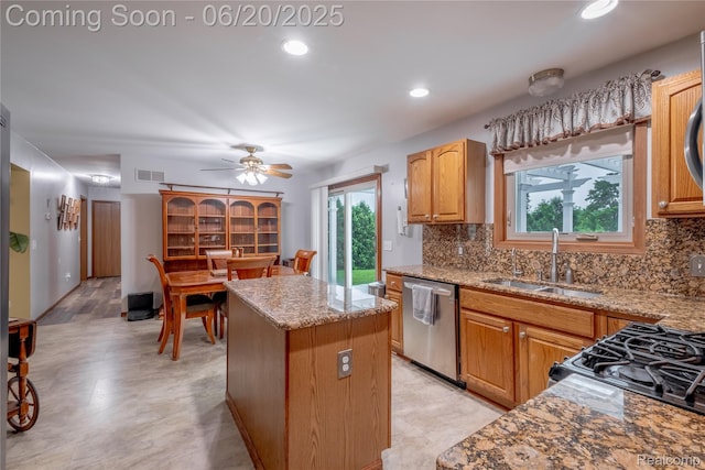 8420 Beers Rd, Swartz Creek, MI 48473 - kitchen featuring stainless steel dishwasher, a kitchen island, backsplash, light stone countertops, and ceiling fan