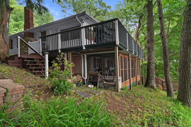 3184 N Lakeshore Dr, Hillsdale, MI 49242 - back of property featuring a chimney, a wooden deck, a sunroom, and stairway