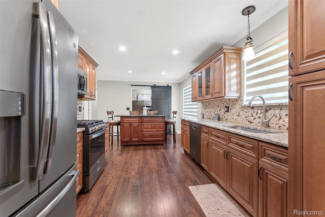 4981 Harding St, Dearborn Heights, MI 48125 - kitchen with stainless steel appliances, dark wood-style floors, ornamental molding, brown cabinets, and a barn door