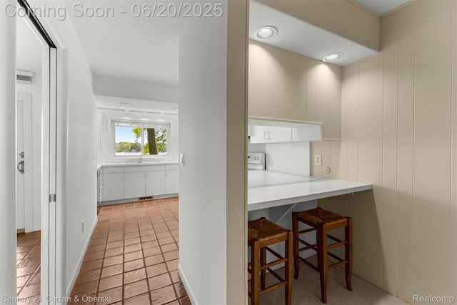3150 Wellington Ct, West Bloomfield, MI 48324 - kitchen with a breakfast bar area, white cabinetry, and light countertops