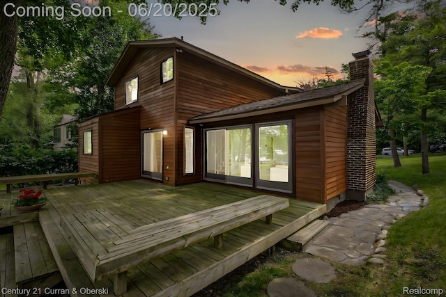 3150 Wellington Ct, West Bloomfield, MI 48324 - back of property at dusk featuring a chimney and a wooden deck