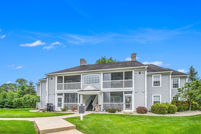 749 W Barrington Cir, Jackson, MI 49203 - back of property featuring a chimney, a yard, and a sunroom
