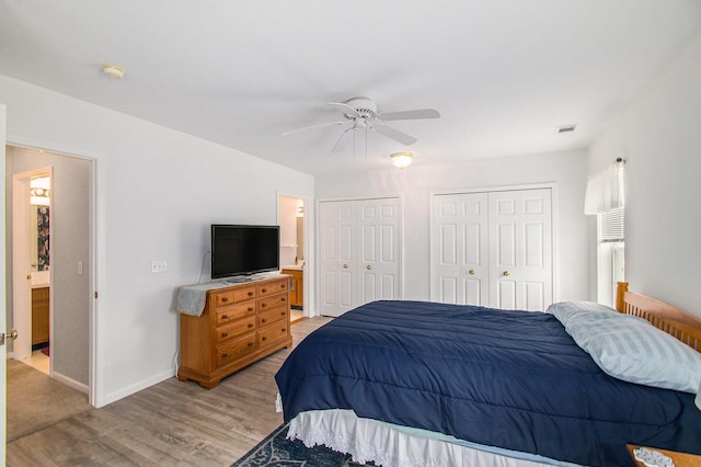 749 W Barrington Cir, Jackson, MI 49203 - bedroom featuring two closets, light wood finished floors, ensuite bath, and a ceiling fan