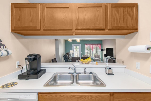 749 W Barrington Cir, Jackson, MI 49203 - kitchen with white dishwasher, light countertops, brown cabinets, and open floor plan