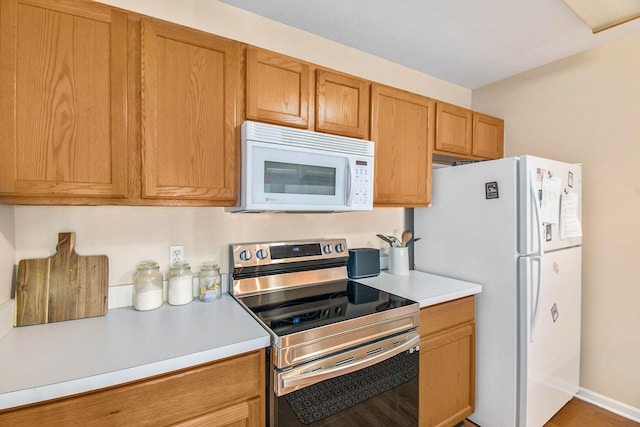 749 W Barrington Cir, Jackson, MI 49203 - kitchen with white appliances, light countertops, and brown cabinets