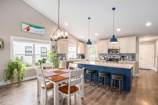964 Everett Pkwy, South Haven, MI 49090 - dining area featuring wood finished floors, recessed lighting, a chandelier, and high vaulted ceiling