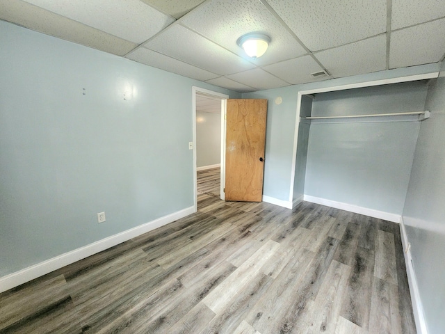 254 Holly St SW, Grand Rapids, MI 49548 - unfurnished bedroom with a drop ceiling, wood finished floors, and a closet