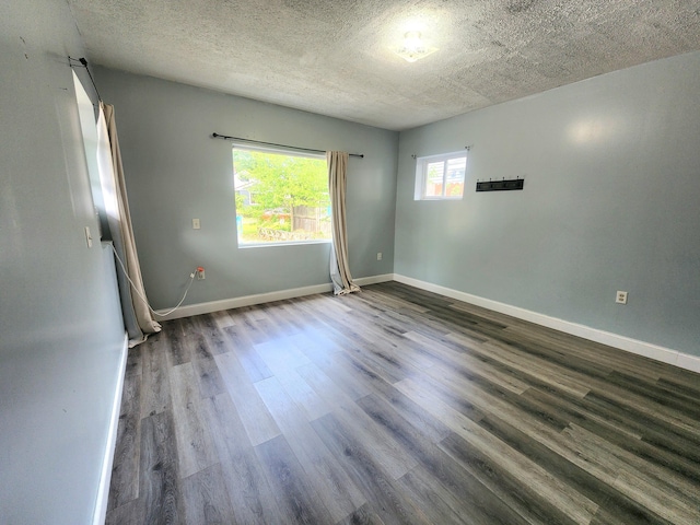 254 Holly St SW, Grand Rapids, MI 49548 - unfurnished room with dark wood-style flooring and a textured ceiling