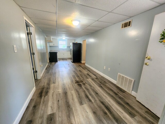 254 Holly St SW, Grand Rapids, MI 49548 - unfurnished living room with a drop ceiling and dark wood-style floors