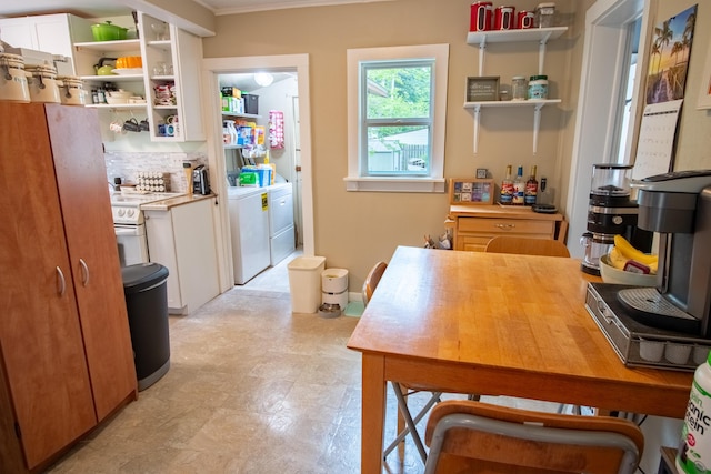 412 E Jefferson St, Hart, MI 49420 - kitchen featuring open shelves, independent washer and dryer, white cabinets, ornamental molding, and backsplash