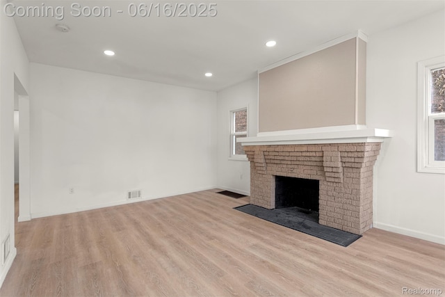 7432 Churchill St, Detroit, MI 48206 - unfurnished living room featuring wood finished floors, healthy amount of natural light, recessed lighting, and a brick fireplace