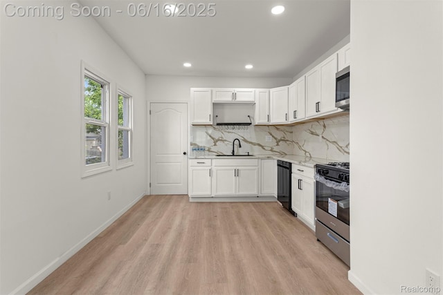 7432 Churchill St, Detroit, MI 48206 - kitchen with stainless steel appliances, light wood-style floors, white cabinetry, recessed lighting, and decorative backsplash