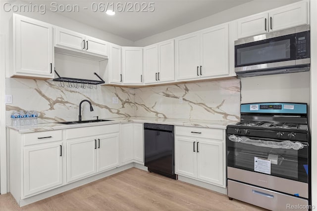7432 Churchill St, Detroit, MI 48206 - kitchen with appliances with stainless steel finishes, white cabinets, light wood-type flooring, and light stone countertops