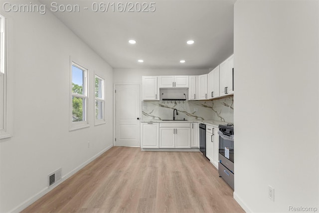 7432 Churchill St, Detroit, MI 48206 - kitchen with stainless steel range with gas stovetop, recessed lighting, white cabinets, light wood-style flooring, and tasteful backsplash