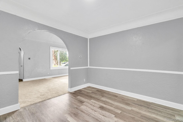 17196 Murray Hill St, Detroit, MI 48235 - empty room with arched walkways, a textured wall, and wood finished floors