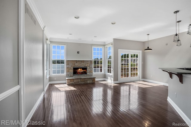 24825 Reeds Pointe Dr, Novi, MI 48374 - unfurnished living room featuring healthy amount of natural light, dark wood-style floors, a fireplace, and crown molding