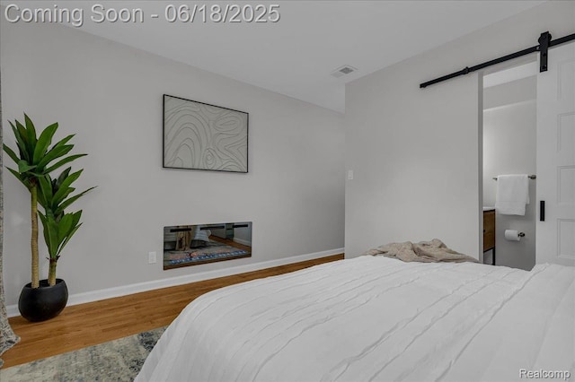 19505 Santa Barbara Dr, Detroit, MI 48221 - bedroom featuring a barn door and wood finished floors