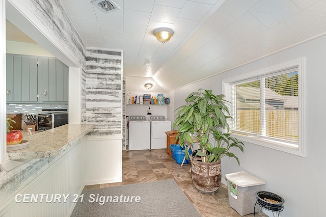 2942 Harrison St, Saginaw, MI 48604 - kitchen featuring separate washer and dryer, lofted ceiling, and light countertops