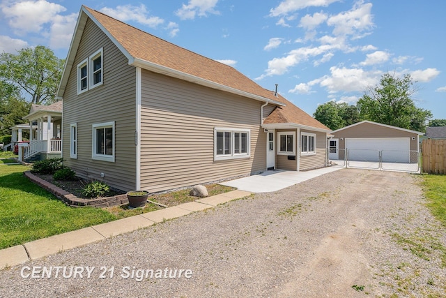 2942 Harrison St, Saginaw, MI 48604 - view of front of house with an outbuilding, a detached garage, and a shingled roof