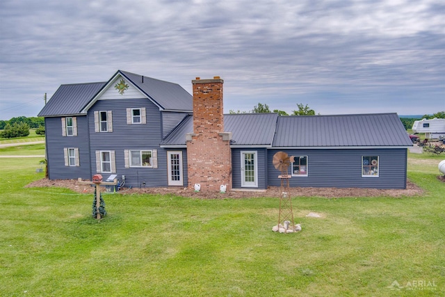 4441 Deckerville Rd, Lupton, MI 48635 - rear view of house featuring a chimney, a lawn, and a metal roof