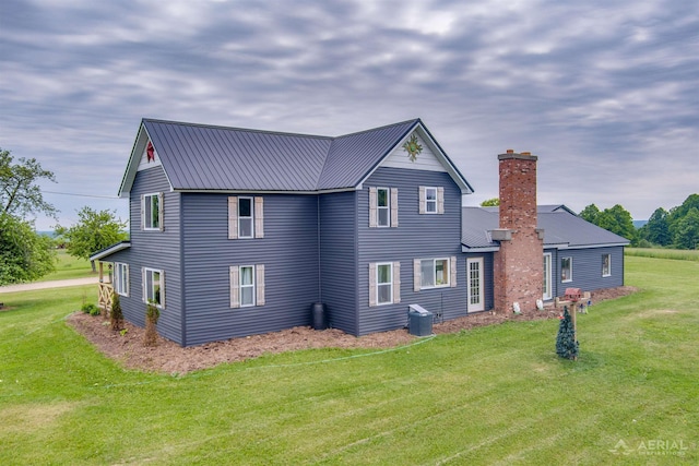 4441 Deckerville Rd, Lupton, MI 48635 - rear view of property featuring a chimney, a lawn, and a metal roof