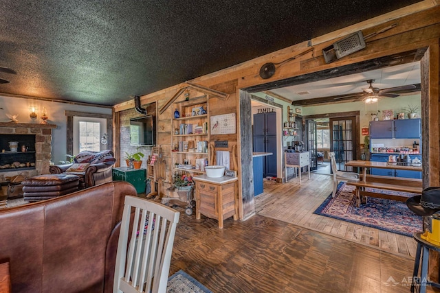 4441 Deckerville Rd, Lupton, MI 48635 - living area with a ceiling fan, hardwood / wood-style floors, a stone fireplace, ornamental molding, and wood walls