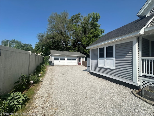 403 N Oak St, Durand, MI 48429 - view of side of property with a detached garage, roof with shingles, and an outdoor structure