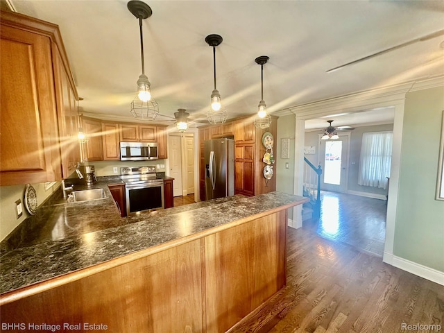 403 N Oak St, Durand, MI 48429 - kitchen featuring stainless steel appliances, a ceiling fan, dark countertops, dark wood finished floors, and crown molding