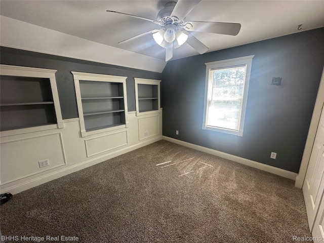 403 N Oak St, Durand, MI 48429 - spare room featuring built in shelves, ceiling fan, and dark colored carpet