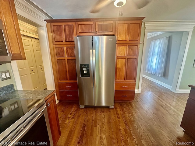 403 N Oak St, Durand, MI 48429 - kitchen with stainless steel appliances, ceiling fan, dark wood-style flooring, dark countertops, and brown cabinetry