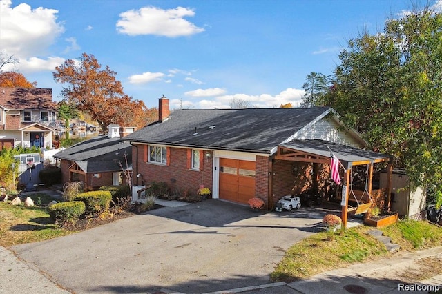 6003 Rolton Ct, Waterford, MI 48329 - view of front of property with asphalt driveway, brick siding, a chimney, a garage, and a shingled roof