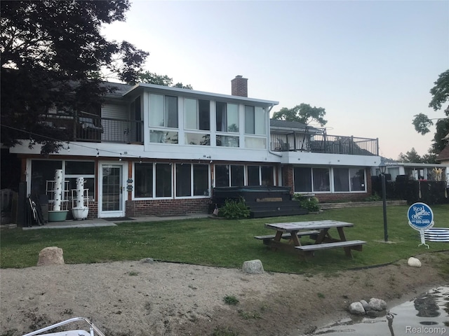 6003 Rolton Ct, Waterford, MI 48329 - back of house featuring brick siding, a balcony, a chimney, and a lawn